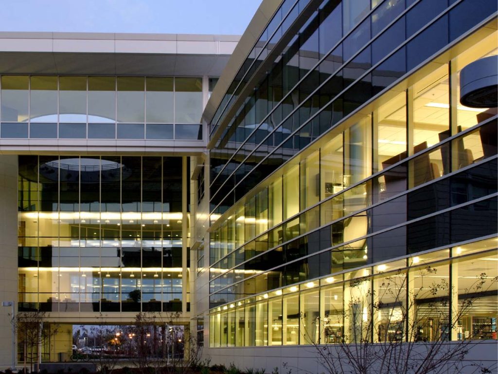 front of large office building at night with interior lights on